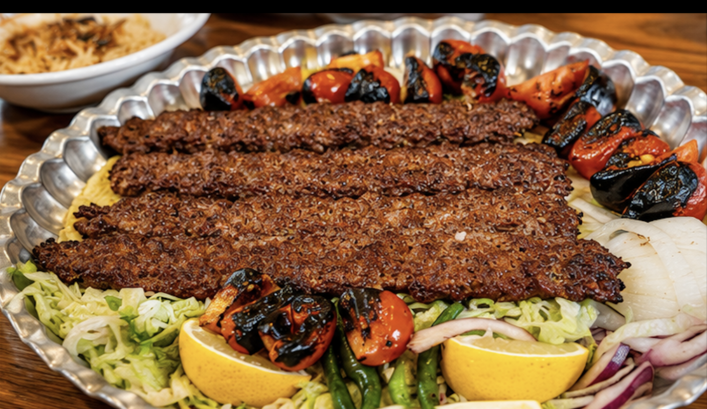 A signature kebab platter with grilled tomatoes and peppers