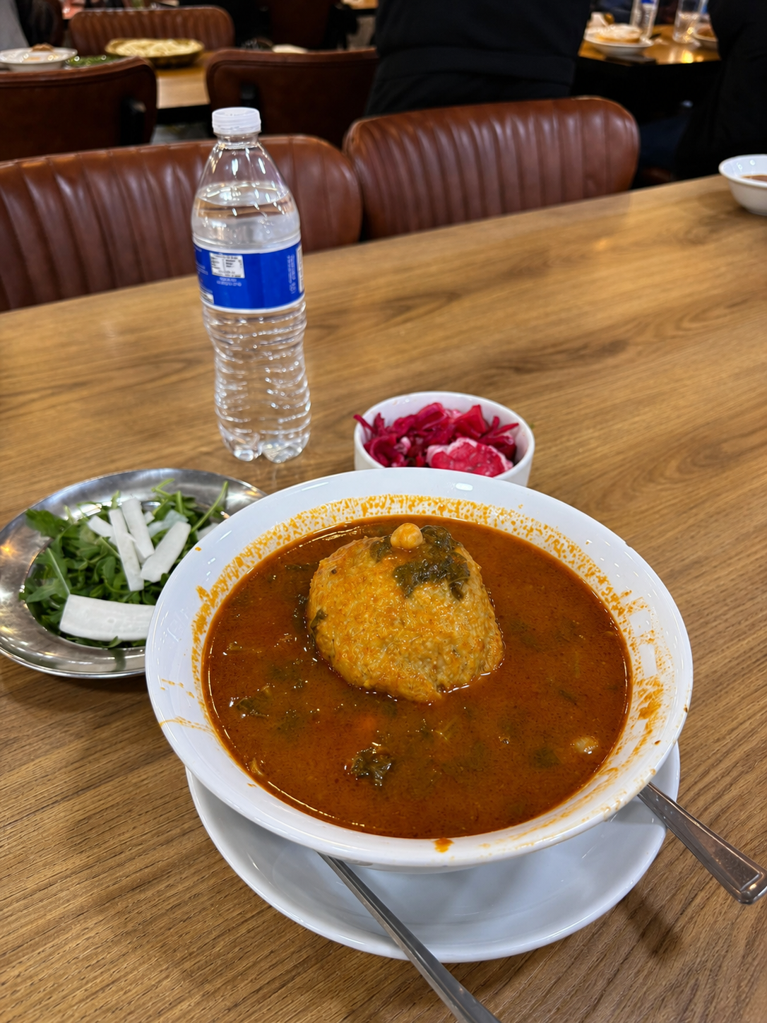 Kibbeh in tomato broth with pickled cabbage and rocket salad